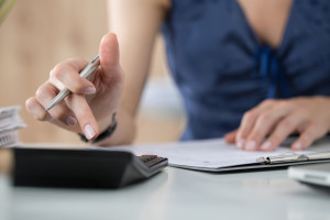 Close Up Of Female Accountant Or Banker Making Calculations